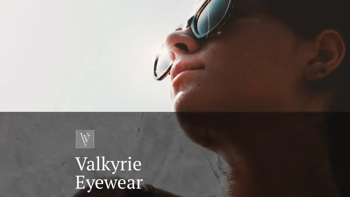 Close up of model in sunglasses behind Valkyrie Eyewear brand logo.
